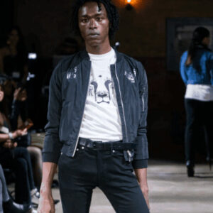 A model showcasing a stylish and sustainable vegan outfit from The Honest Whisper during a fashion show.