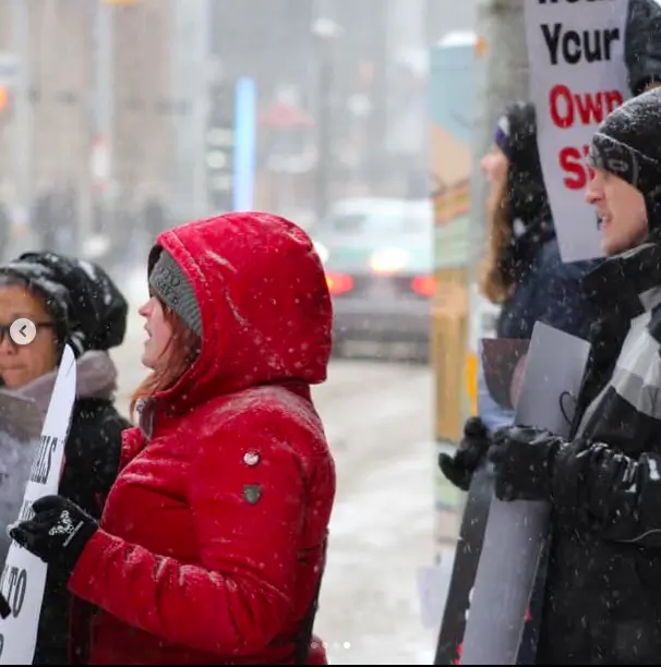 A group of animal rights activists, with one person wearing gloves from The Honest Whisper.