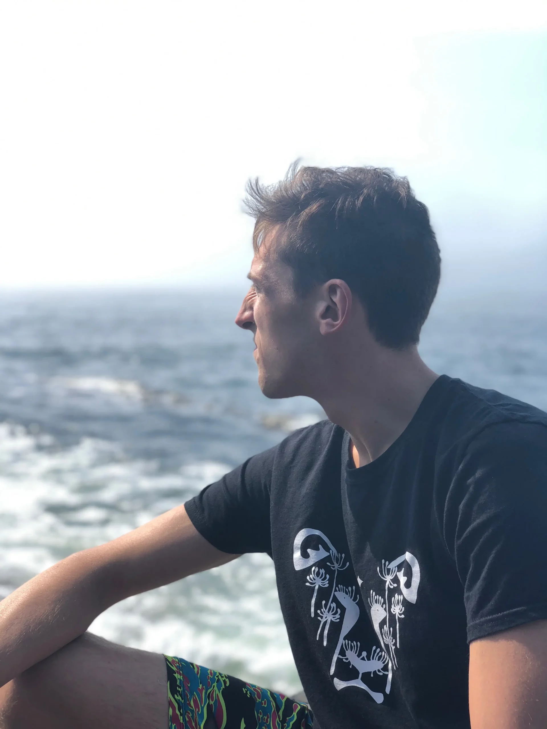 A man wearing a t-shirt featuring the DandiLion logo from The Honest Whisper, a brand known for its ethical and sustainable fashion.