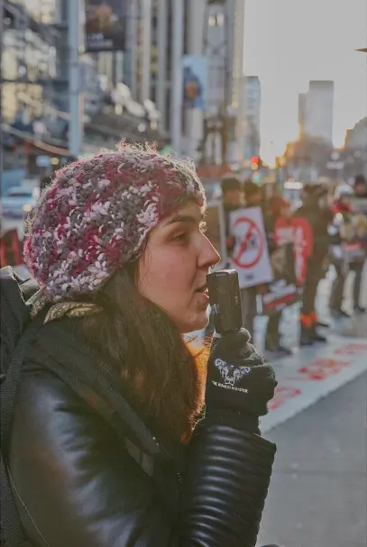 Georgia wearing gloves from The Honest Whisper while attending an animal rights activism event.