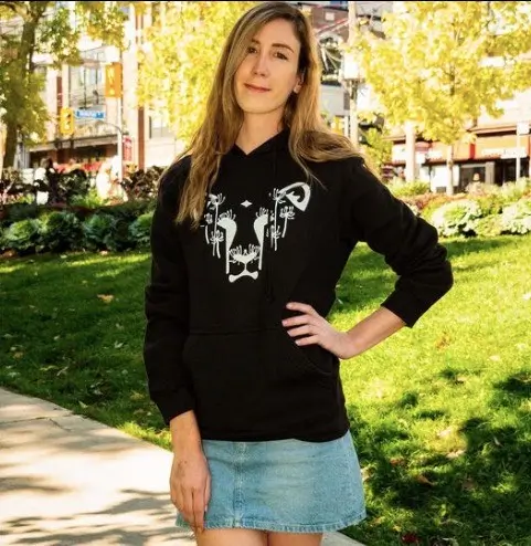 Laura wearing a black hoodie with the Dandi Lion logo from The Honest Whisper, a brand known for its ethical and sustainable fashion.